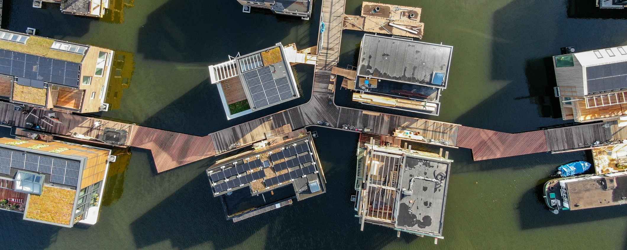 Luchtfoto van woonboten. Houten steigers verbinden de huizen met elkaar.