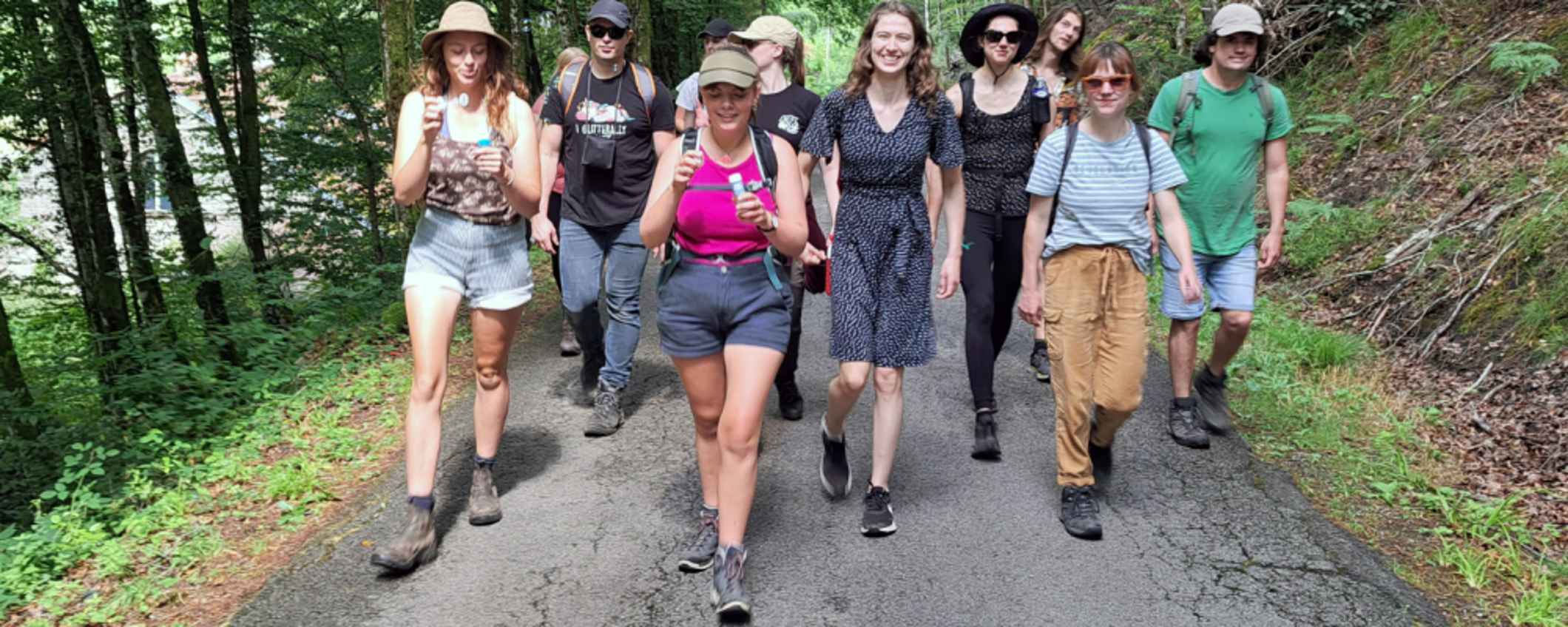 Een groep jongeren loopt buiten door het bos.