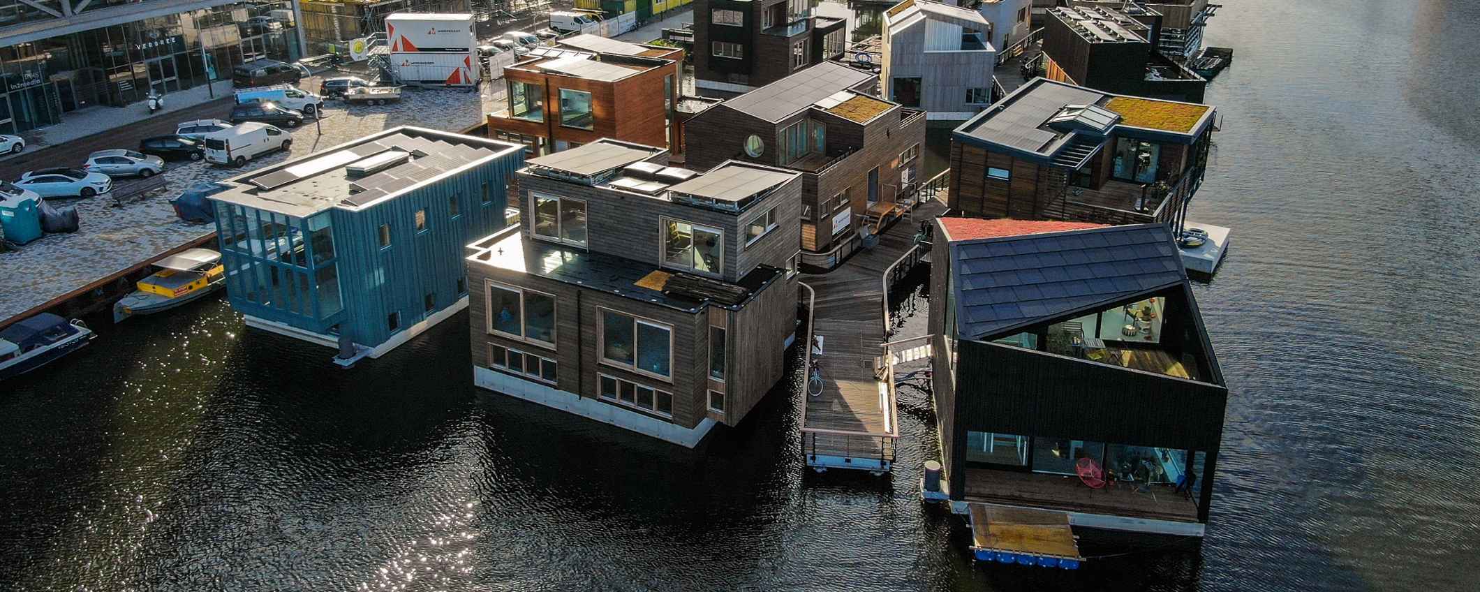 Luchtfoto van woonboten op het water. Steigers verbinden de huizen met elkaar en met de kade.