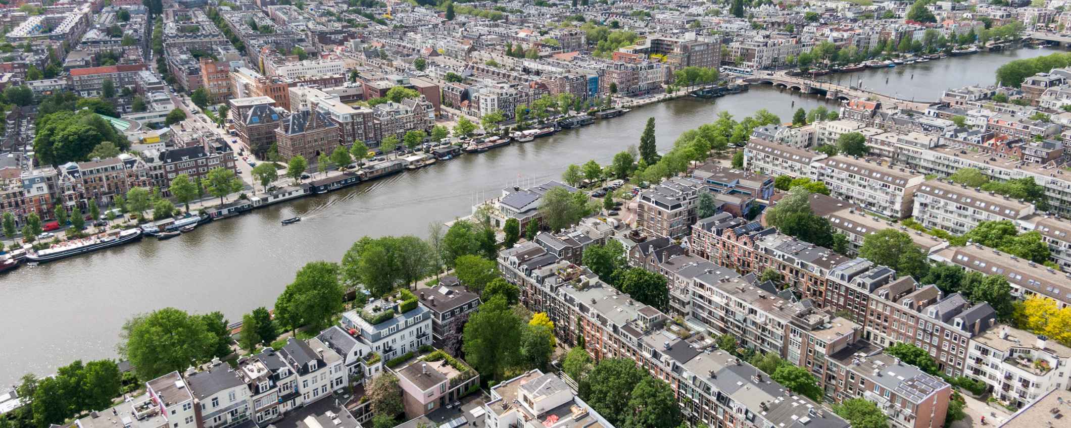 Luchtfoto van een kanaal omgeven door woonhuizen en andere gebouwen.